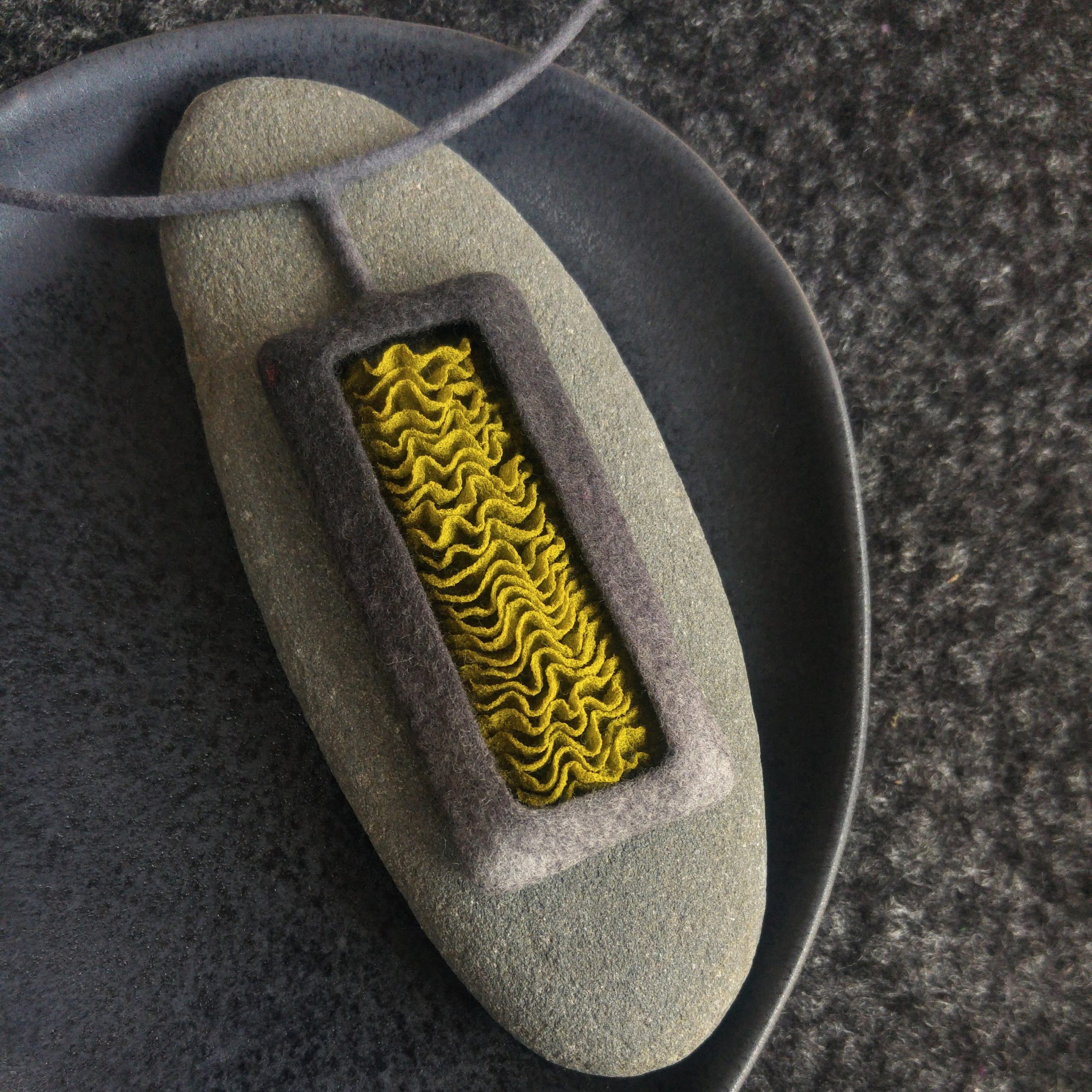 Necklace in grey with wavy silk inlay in light olive green.